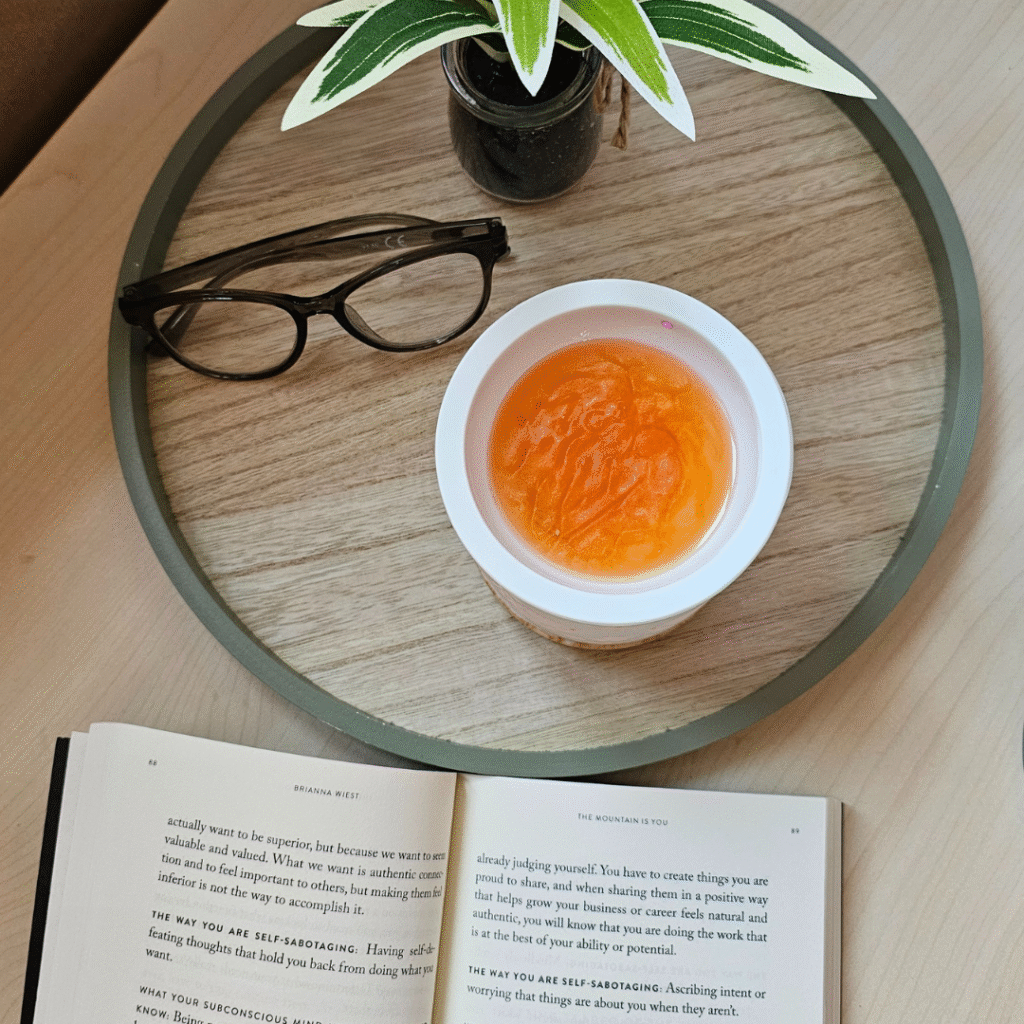 Rumenkasti vosek v izparilniku ob odprti knjigi in rastlini – ustvarja mirno vzdušje za fokus in produktivnost.Rumenkasti vosek v izparilniku ob odprti knjigi in rastlini – ustvarja mirno vzdušje za fokus in produktivnost.